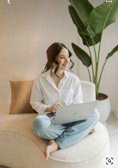 a woman sitting on a couch using a laptop computer