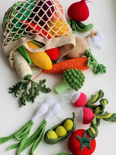 crocheted vegetables are sitting on a white surface