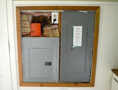 an electrical panel in the corner of a room with some boxes and other items on it