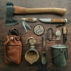 an assortment of gardening tools and other items on a wooden table with a leather pouch