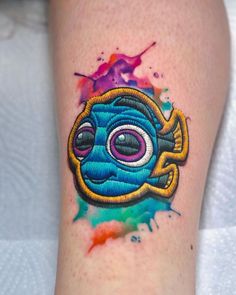 a tattoo on the leg of a person with a blue and yellow object in it