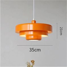 an orange pendant light hanging from a ceiling fixture with measurements for the size and width