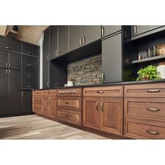 a kitchen with dark cabinets and wood floors