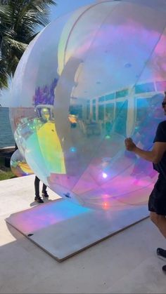 a man standing in front of a giant bubble ball