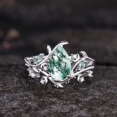 a ring with green stones and leaves on it