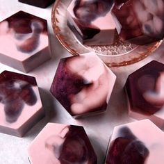 several pieces of soap sitting on top of a table next to a glass bowl and plate