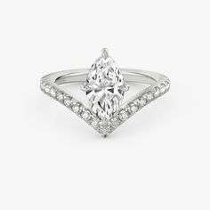 an engagement ring with a pear shaped diamond in the center and pave set shoulders