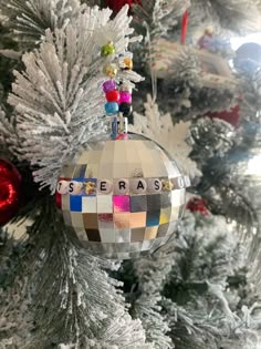 an ornament hanging from the side of a christmas tree with words on it