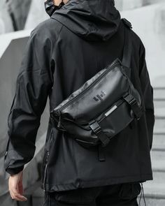 An Authentic Techwear Style with the  Sling Bag "Kekai" Elevate your urban fashion game with the Techwear Sling Bag "Kekai". Crafted from high-quality polyester, this bag is not only comfortable to touch  but also boasts durable features  like anti-scratch and waterproof capabilities.  This sling bag is a perfect blend of  style and practicality , making it an essential accessory for any urban explorer.  Why Choose the Techwear Sling Bag "Kekai"? The multifunctional design  of this sling bag sets it apart. It features a magnetic closure shoulder strap  for quick removal, a built-in retractable keychain to prevent losing keys, and a fixed strap at the bottom to hold a photo tripod. If you like this bag and want to see more styles, check out our sling bag collection.  Versatile and Practical Large Capacity Shoulder Chest Bag For Streetwear, Large Capacity Chest Shoulder Bag For Streetwear, Streetwear Shoulder Chest Bag With Large Capacity, Streetwear Large Capacity Chest Shoulder Bag, Casual Rectangular Chest Bag For Streetwear, Black Casual Chest Bag For Streetwear, Casual Black Chest Bag For Streetwear, Urban Crossbody Shoulder Bag For Streetwear, Casual Chest Bag With Adjustable Strap For Streetwear