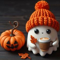 a cute little doll with a cup of coffee next to a pumpkin and a jack - o'- lantern