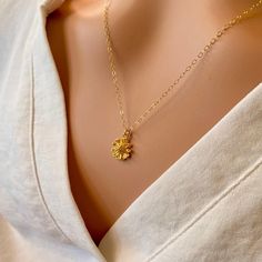 A beautiful small, shiny gold flower with lots of detail is hung on a delicate yet sturdy 14K Gold-Filled Chain. Sweet and simple. Feminine and charming. - Pendant - 14k Gold plated Brass - 9mm in diameter - Chain + components - 14K Gold-Filled - Clasp - 14K Gold-Filled lobster clasp . . . . . . . . . . . . . . . . . . . . . . . . . . . . . . . .  Want more for bridesmaids, sisters or friends? I am happy to put custom orders together! . . . . . . . . . . . . . . . . . . . . . . . . . . . . . . . .  Necklace arrives packaged for giving. Yellow Gold Flower Charm Necklace, Gold Dainty Flower Pendant Charm Necklace, Dainty Flower Charm Necklace For Wedding, Gold Charm Necklace With Flower Pendant And Delicate Chain, Yellow Gold Flower Charm Necklace With Delicate Chain, Elegant Gold Charm Necklace With Flower Charm, Dainty 14k Gold Charm Necklace With Flower Charm, Elegant Gold Charm Necklace With Flower Detail, 14k Gold Flower Charm Necklace With Pendant