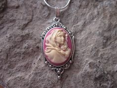 "Beautiful Virgin Mary cradling baby Jesus cameo necklaces I can make matching earrings, brooch and a bracelet also, so please feel free to message me, and I will set up a custom/reserved listing. The cameos are gorgeous, choose from black or pink I do have other colors and styles, so please do browse, I can make any cameo in my shop into this pretty necklace, so browse and message me with a custom order The pretty setting is about 1 1/2\" long, please do see the photo The chain is a 22\" .925 s Personalized Pink Jewelry For Christmas, Handmade Pink Jewelry For Christmas, Sterling Silver Cameo Jewelry For Gift, Handmade Vintage Jewelry For Mom, Spiritual Jewelry For Christmas Gift, Red Cameo Necklace For Gift, Red Cameo Jewelry Gift, Pink Adjustable Christmas Jewelry, Cameo Jewelry Gift