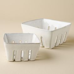 two white dishes sitting side by side on a beige surface, one is empty and the other has no lid