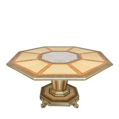 a table with a glass top and gold trimmings on the base, sitting in front of a white background