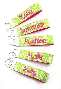 four green and pink paper clips with the word monogrammed on them, sitting next to each other