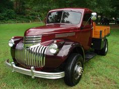 an old truck is parked in the grass