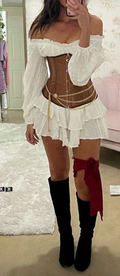 a woman wearing a corset and boots taking a selfie in a mirror