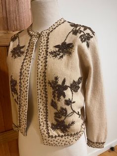 A glorious champagne lambswool cardigan with stunning gold beading in absolutely immaculate condition.  The beading is lavish and generous, decorating both the back and the front.  Fully lined.  This garment will elevate the plainest black dress to create an evening look.  Beautiful over a summer dress for a boho feel  or sweet for a date night look worn with jeans.  A beautiful and versatile treasure from the 50s.  Ideal for a size 6 to 8. Cream Cardigan For Fall Wedding, Cream Wedding Cardigan For Fall, Fall Wedding Cream Cardigan, Cream Formal Cardigan For Winter, Elegant Gold Sweater For Winter, Elegant Gold Winter Sweater, Elegant Embellished Sweater For Fall, Elegant Embellished Formal Cardigan, Formal Embellished Winter Cardigan