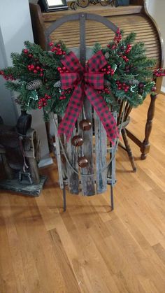 a wooden sled with wreaths and pine cones tied to it on top of a hard wood floor