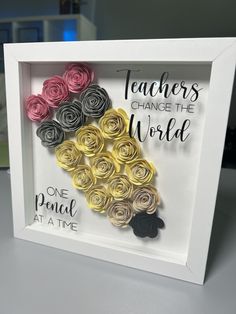 a white frame with some paper flowers in it