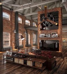 a large living room with exposed brick walls and wood flooring is pictured in this image