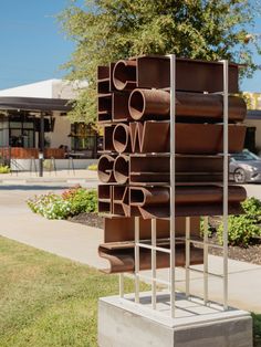 a tall metal sculpture sitting on top of a cement block