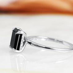 a black and white diamond ring sitting on top of a table