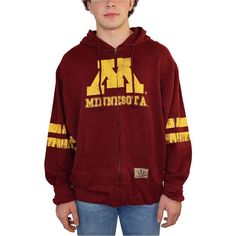 Feel The Embrace Of Cozy Warmth With The Izod Mens Collegiate Full Zip Hooded Sweatshirt. With Its Manufacturing Origins Unknown, This 100% Cotton Sweatshirt Becomes An Emblem Of Casual Grace. The Minnesota Graphic Across The Front, Dual Kangaroo Pockets, And Full-Zipped Front Come Together To Create A Look That's Both Chic And Functional.The Drawstring Closure At The Top Adds A Personalized Touch, While The Long Sleeves Keep You Snug And Comfortable. Perfect For A Casual Outing Or A Lazy Day At Winter Fan Merchandise Cotton Hoodie, Cotton Hooded Tops For Fan Gear, Cotton Hooded Top For Fan Merchandise, Cotton Sweatshirt With Drawstring Hood For Fans, Winter Cotton Outerwear For Fan Merchandise, Throwback Cotton Hoodie Tops, Cotton Varsity Hooded Top, Cotton Hooded Varsity Tops, Cotton Throwback Sweatshirt For Fan Gear