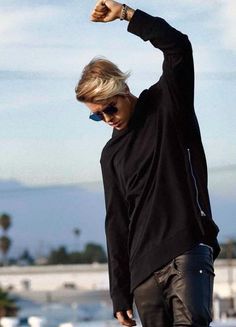 a young man is skateboarding on the street with his hand up in the air