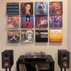 there are many records on the wall next to each other and speakers in front of them