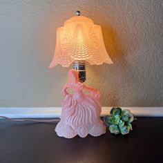 a lamp that is on top of a table next to a succulent plant