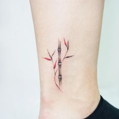 a small tattoo on the ankle of a woman's foot with a knife stuck in it