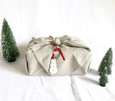 a bag with a snowman decoration on it and small trees in the back ground