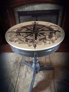 a table with a compass on it in front of a fireplace