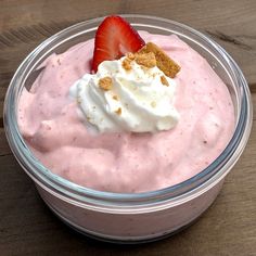 a bowl filled with fruit and cream on top of a wooden table