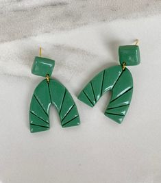 the green earrings are shaped like leaves