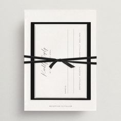 a black and white wedding card with a ribbon tied around it