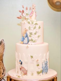 a three tiered cake decorated with rabbits and flowers