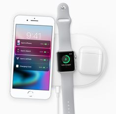 an apple watch and charging station with earphones on the side, next to each other