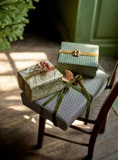 two wrapped presents sitting on top of a wooden chair