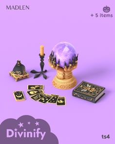 a purple background with black and gold items on it, including a candle, cards, and other decorative objects