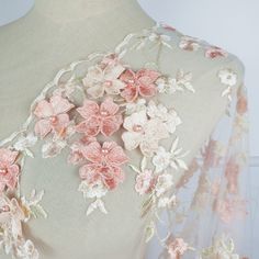 the back of a dress with pink flowers on it and sheer lace overlays