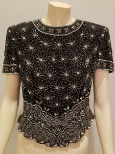 REDUCED from $66 exquisite art deco styling on this beaded evening top from Adrianna Papell, vintage 1980s, black silk with heavy silver beadwork, short sleeves, back zipper, scalloped waist, strong shoulder padding, fully lined in black satin size L, bust 37, waist 33, shoulders 16 1/2, sleeves 8, length 21, excellent condition Formal Black Embellished Tops, Elegant Beaded Evening Top, Elegant Beaded Tops For Formal Occasions, Elegant Beaded Tops For Evening, Elegant Beaded Tops For Party Season, Formal Beaded Tops For Summer, Vintage Embellished Evening Blouse, Glamorous Beaded Evening Tops, Vintage Beaded Fitted Tops