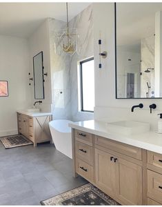 a large bathroom with two sinks and a bathtub next to a window in the corner