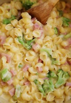 a close up view of macaroni and cheese with broccoli in it