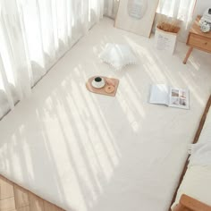 a bedroom with white bedding and wooden furniture in the corner, along with an open window