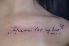 a woman with a tattoo on her chest saying heaven has my heart written in cursive writing