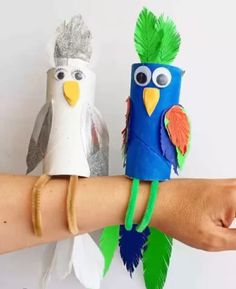 two birds made out of toilet paper sitting on top of each other's arm