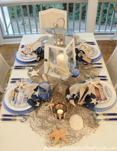 the table is set with blue and white plates, napkins, and silverware