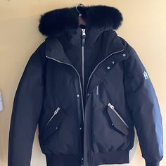 Brand New Luxury Black Sport Coat For Winter, Luxury Black Winter Sport Coat, Black Luxury Winter Sport Coat, Black Luxury Outdoor Outerwear, Modern Black Outerwear With Padded Collar, Black Luxury Outerwear, Luxury Black Outerwear With Pockets, Luxury Black Parka For Winter, Moisture-wicking Hooded Jacket For Streetwear